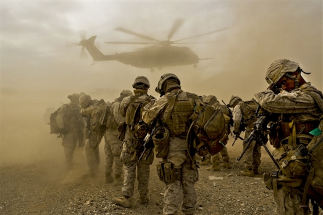 Marines shield their faces from dust a CH-53E Super Stallion kicks up as it lands during Integrated Training Exercise 2-15 at Marine Corps Air Ground Combat Center in Twentynine Palms, Calif., Jan. 25, 2015.