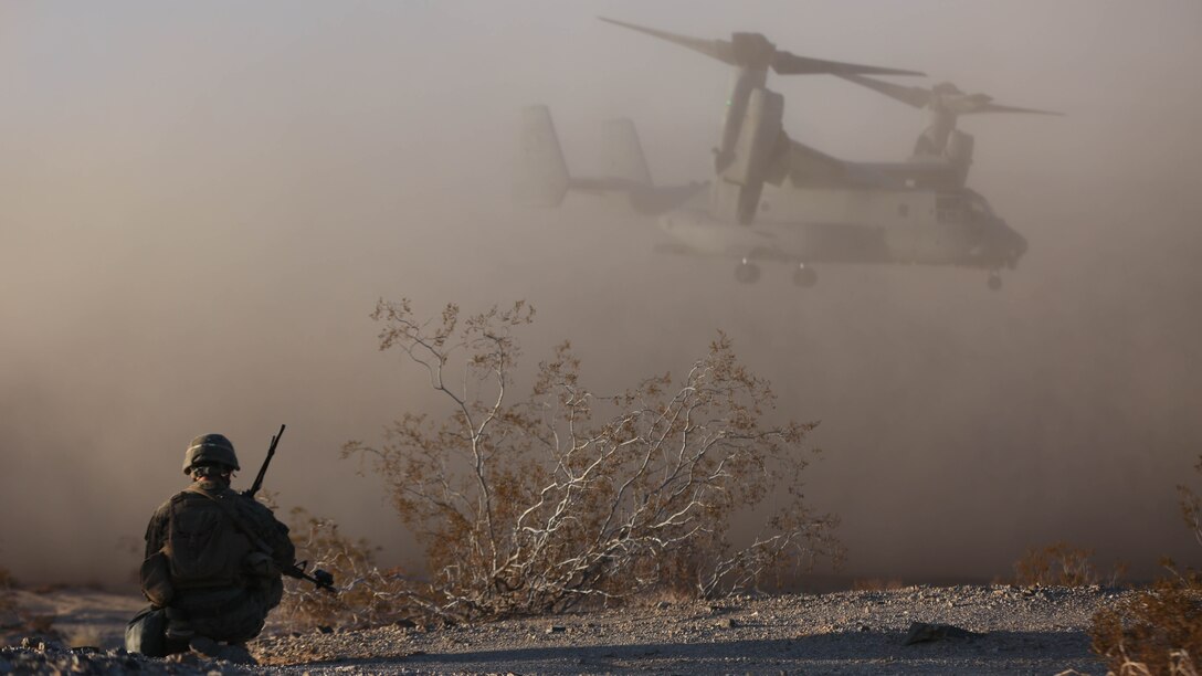 First Lt. Joseph Carroll, Company I Executive Officer, 3rd Battalion, 7th Marine Regiment, a native of Norwood, Mass. looks on as an MV-22B ‘Osprey’ takes off during an air assault on a Military Operation on Urbanized Terrain town during the Marine Corps Combat Readiness Evaluation Exercise, Jan.16, 2015. The exercise tested each company of 3/7 on their ability to perform offensive operations. 