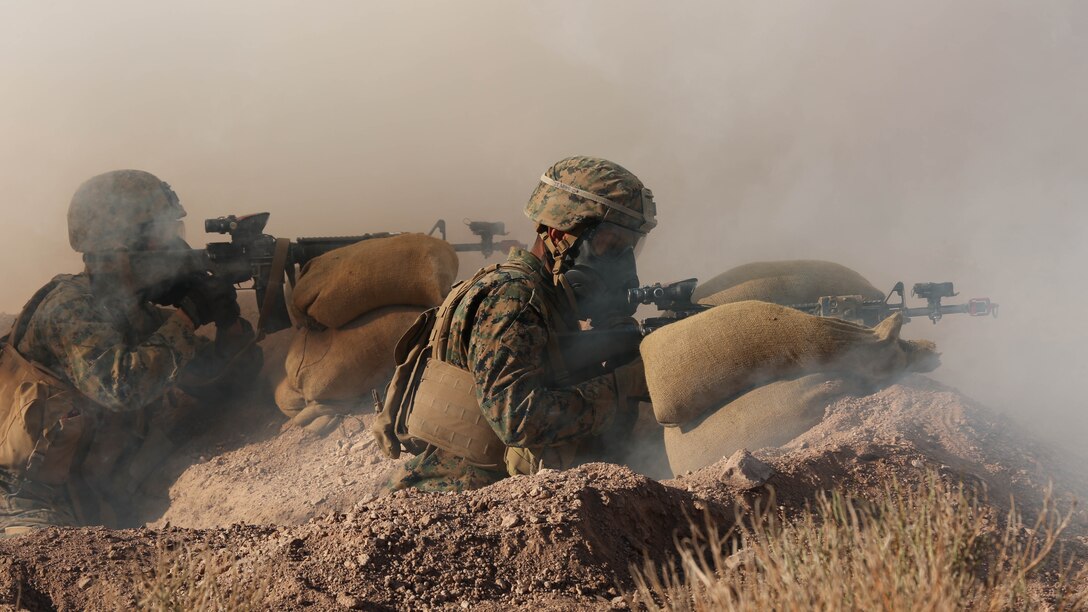 Pfc. Vincent Adames, native of San Antonio, and Pfc. William Estrada, native of Fontana, Calif., riflemen, Company I, 3rd Battalion, 7th Marine Regiment, watch their sectors of fire during an attack with 2-Chlorobenzalmalononitrile, also known as CS Gas, during the Marine Corps Combat Readiness Evaluation Exercise, Jan.15, 2015. The exercise tested the defensive response of 3/7 while tear gas engulfed the area. 