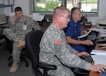 Representatives from the Florida National Guard and the U.S. Coast Guard monitor the oil spill disaster and participate in planning and operations from the State Emergency Operations Center in Tallahassee, Fla., May 13, 2010.