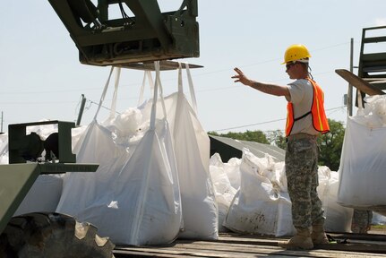 Pfc. Kyle Whitaker of Detachment 1 of the 843rd Horizontal Company, 205th Engineer Battalion of the Louisiana National Guard, directs the Skytrak operator as he loads sandbags on a tractor trailer, which will be used to haul them to a staging area where they will be air-lifted by UH-60 Blackhawk helicopters to fill the breaches on Pelican and Scofield Island, May 17, 2010.