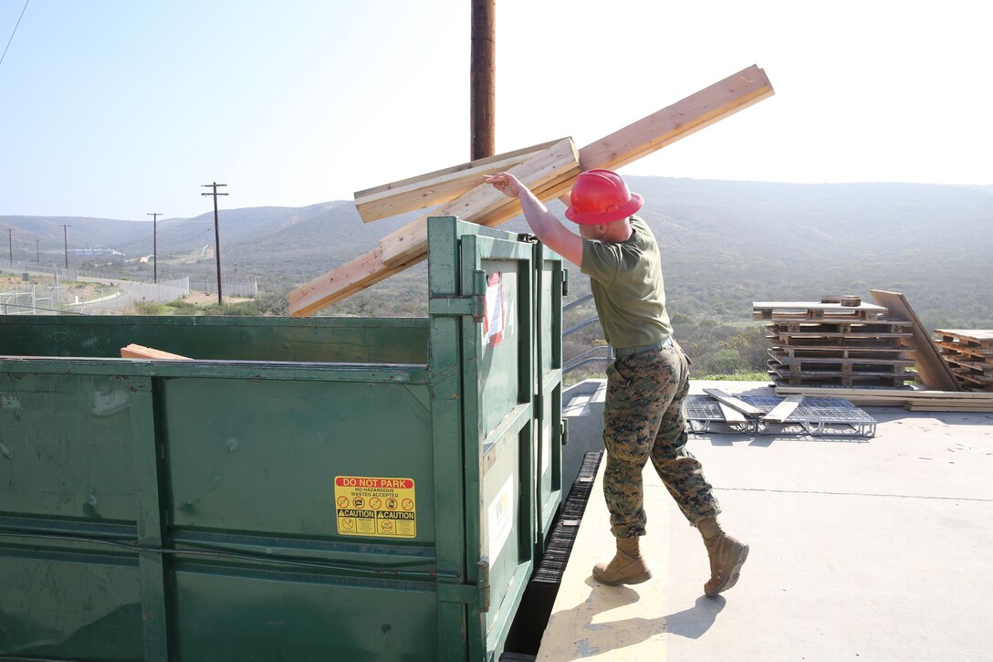Lance Cpl. Corbin McGrath, an aviation ordnance system technician with Headquarters and Headquarters Squadron, throws away wood from delivery truck aboard Marine Corps Air Station Miramar, Calif., Jan. 21. The wood is used to hold pallets of ammunition on delivery trucks.