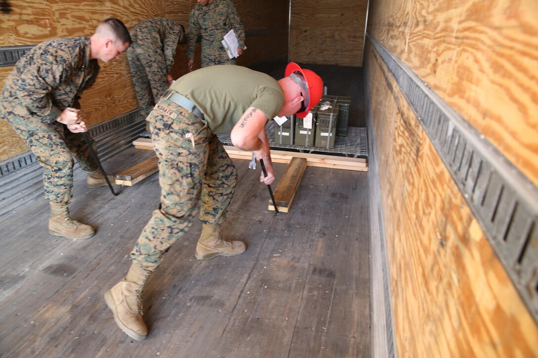 Lance Cpl. Matthew Sheffield, left, and Lance Cpl. Corbin McGrath, right, both aviation ordnance system technicians with Headquarters and Headquarters Squadron, remove wood holding a pallet of ammunition on a delivery truck aboard Marine Corps Air Station Miramar, Calif., Jan. 21. Station ordnance Marines handle the storage of ordnance before it is issued to any squadron.