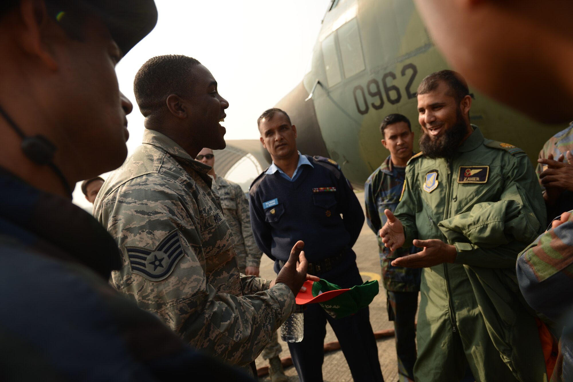 U.S. Air Force Staff Sgt. Justin Price speaks with Bangladesh Air Force maintenance counterparts from the 101st Special Flying Unit during Exercise COPE SOUTH at BAF Base Bangabandhu, Jan. 27, 2015. Price is a repair and reclamation specialist assigned to the 374th Maintenance Squadron, Yokota Air Base, Japan. COPE SOUTH helps cultivate common bonds, foster goodwill, and improve readiness and compatibility between members of the Bangladesh and U.S. Air Forces. (U.S. Air Force photo by 1st Lt. Jake Bailey/Released)