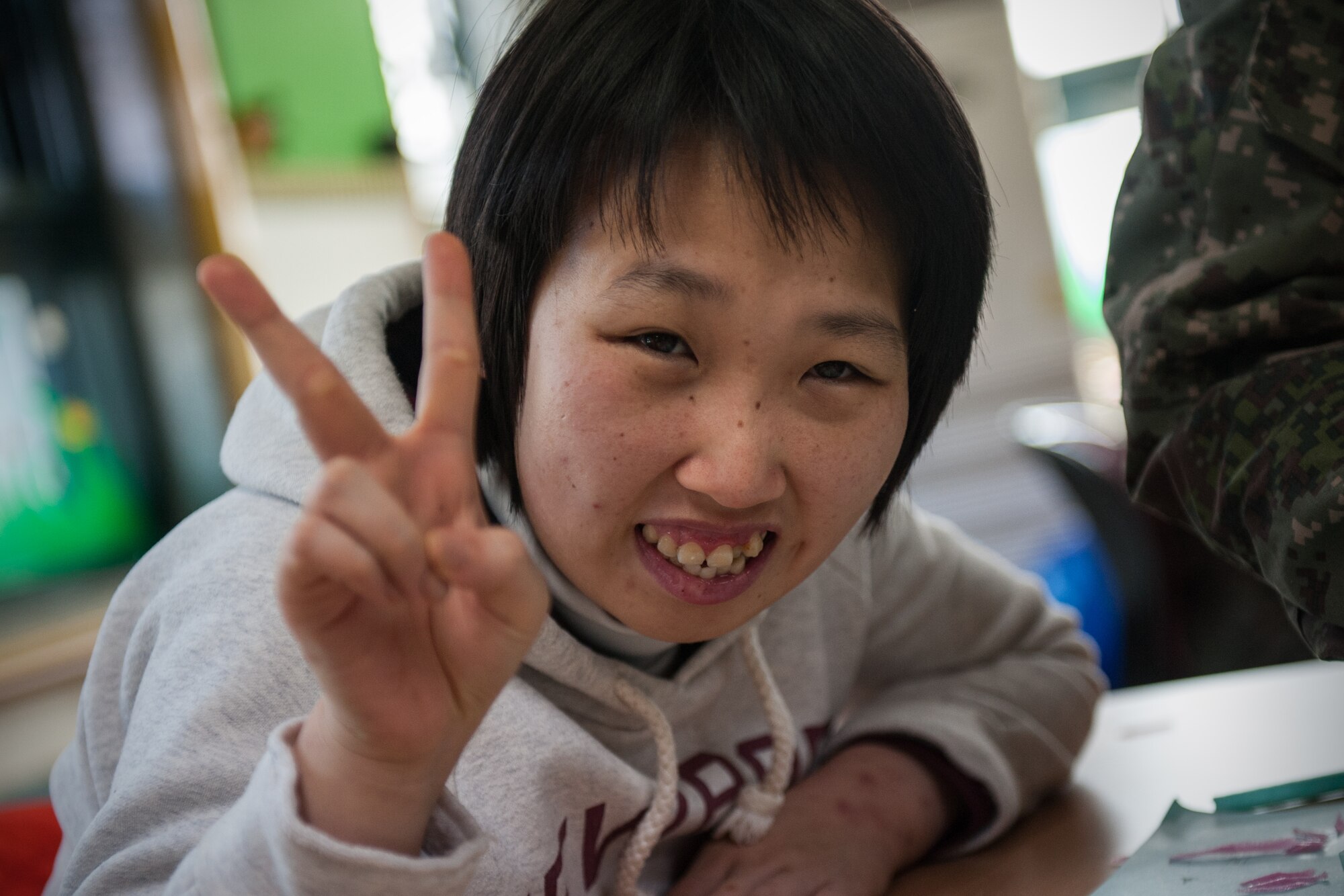 A resident of the Gunsan City Rehabilitation Center poses for a photo during a Kunsan Air Base volunteer event in Gunsan City, Republic of Korea, Jan. 22, 2015. Wolf Pack Airmen and ROK Air Force members volunteered their day to help at the rehabilitation center. (U.S. Air Force photo by Senior Airman Taylor Curry/Released)