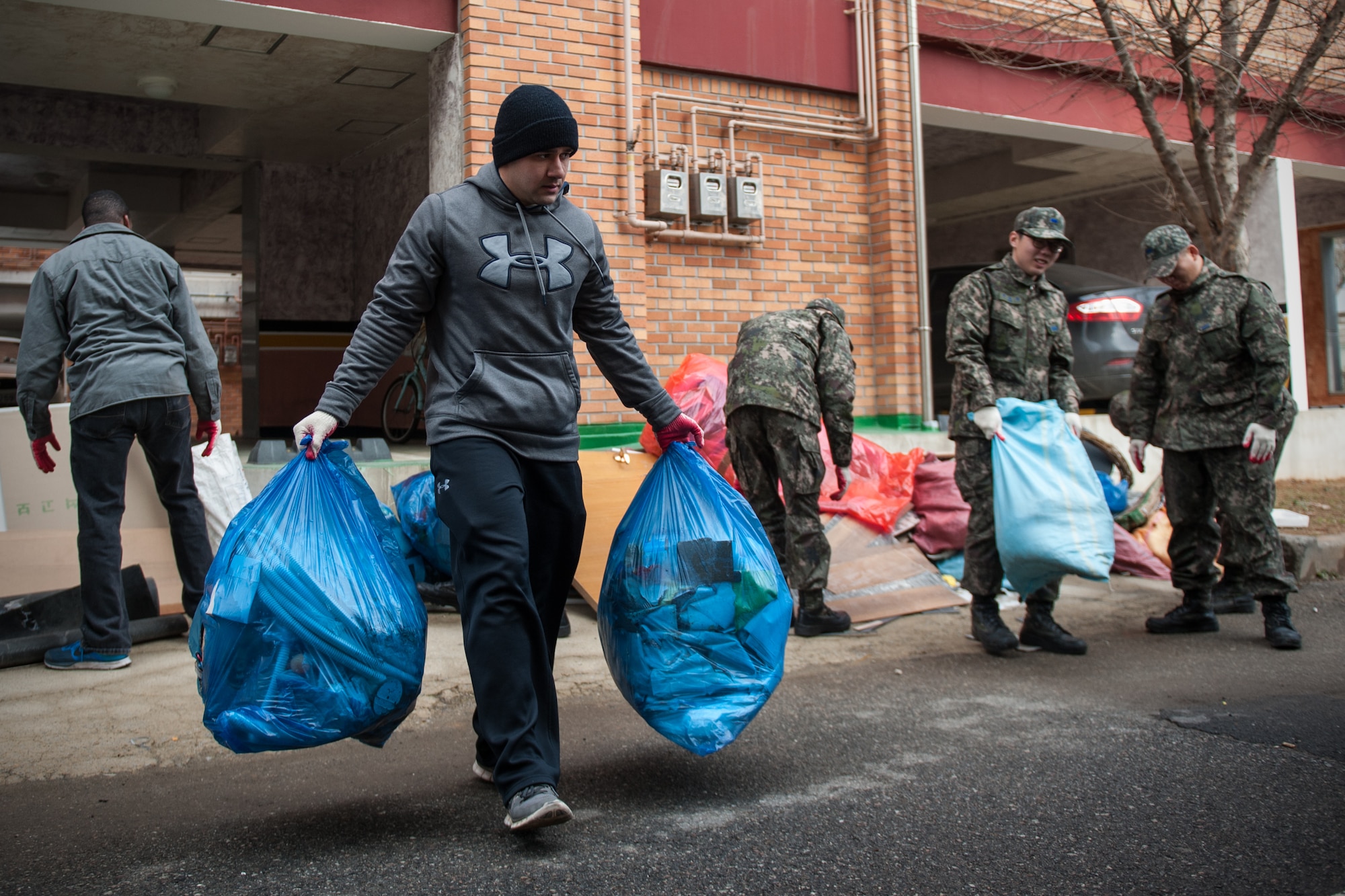 Members of both the Wolf Pack and Republic of Korea Air Force take out trash at the Gunsan City Rehabilitation Center during a volunteer event in Gunsan City, ROK, Jan. 22, 2015. ROKAF and U.S. Air Force members volunteered for the day at the rehabilitation center as part of a monthly community service project. (U.S. Air Force photo by Senior Airman Taylor Curry/Released) 