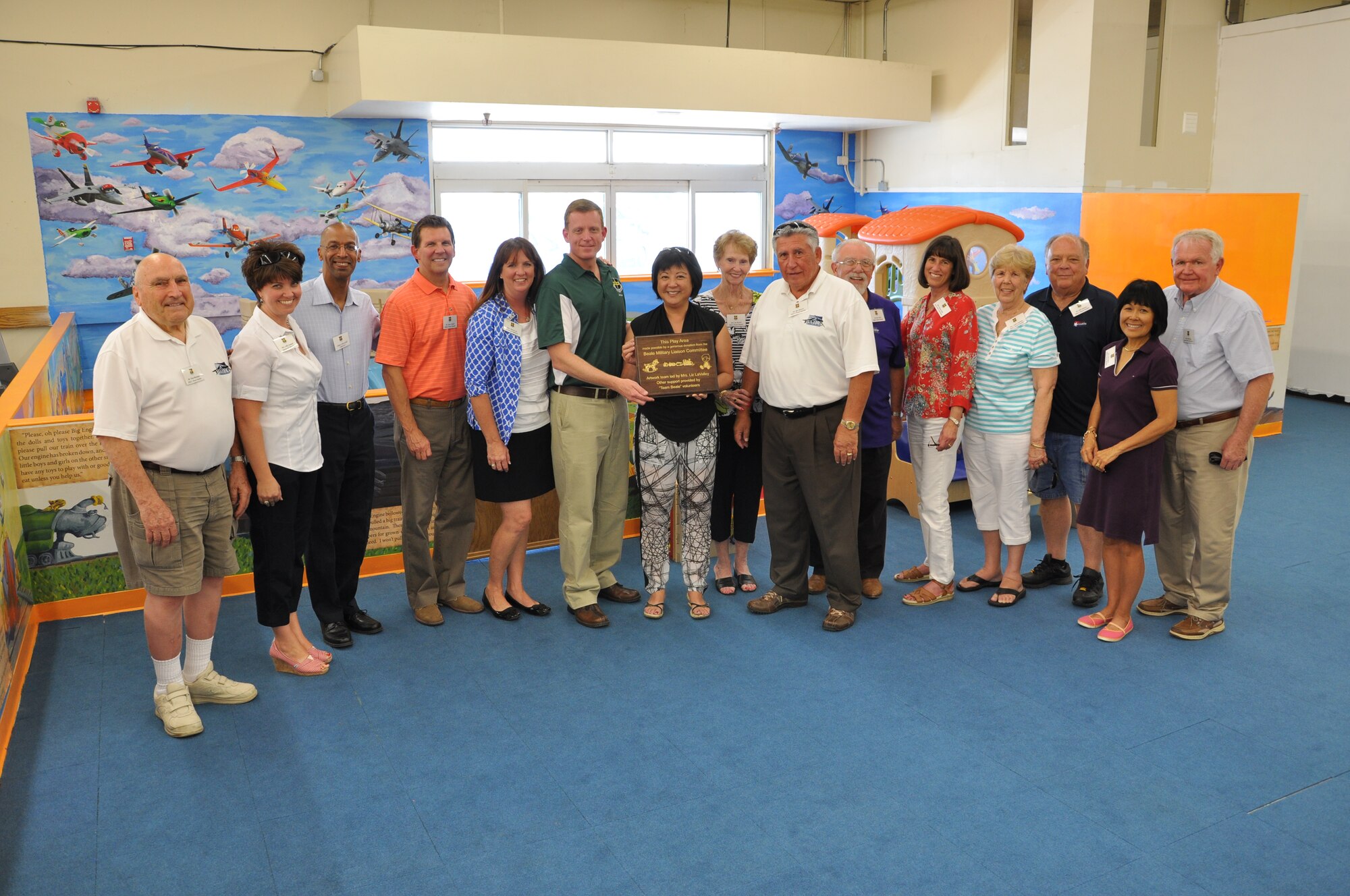 Col. Douglas Lee, 9th Reconnaissance Wing commander, presents members of the Beale Military Liaison Committee with a plaque to commemorate the donation of the Omni Little Dragon Play Area at Beale Air Force Base, Calif., June 25, 2014. In 2014, the BMLC funded more than $40,000 in quality of life projects for Beale Airmen and their families. (U.S. Air Force photo by Sean Bhakta/Released) 