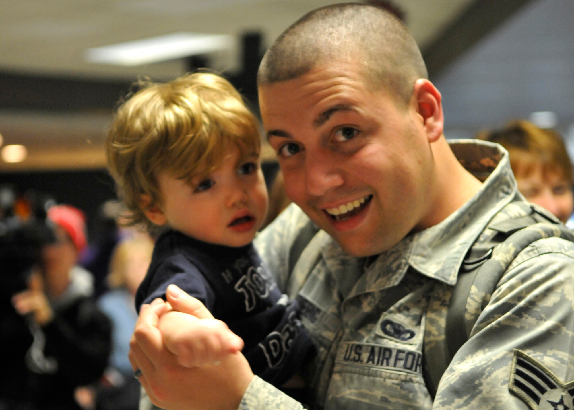 FORT WAYNE AIR NATIONAL GUARD BASE, Ind. – Senior Airman Aaron Strebig, 122nd Fighter Wing, Security Forces, embraces his son as the 122nd Fighter Wing welcomed home more than two-dozen members from the 122nd Security Forces Squadron, as they returned from a six-month deployment in support of Operation Enduring Freedom, January 23, 2015 at the Fort Wayne International Airport.  Twenty-six Blacksnakes mobilized for this deployment and were assigned to the 379th Expeditionary Security Forces Squadron at Al Udeid Air Base, Qatar. The group spent one month in San Antonio conducting combat preparation, then transitioned to Qatar for six months. 