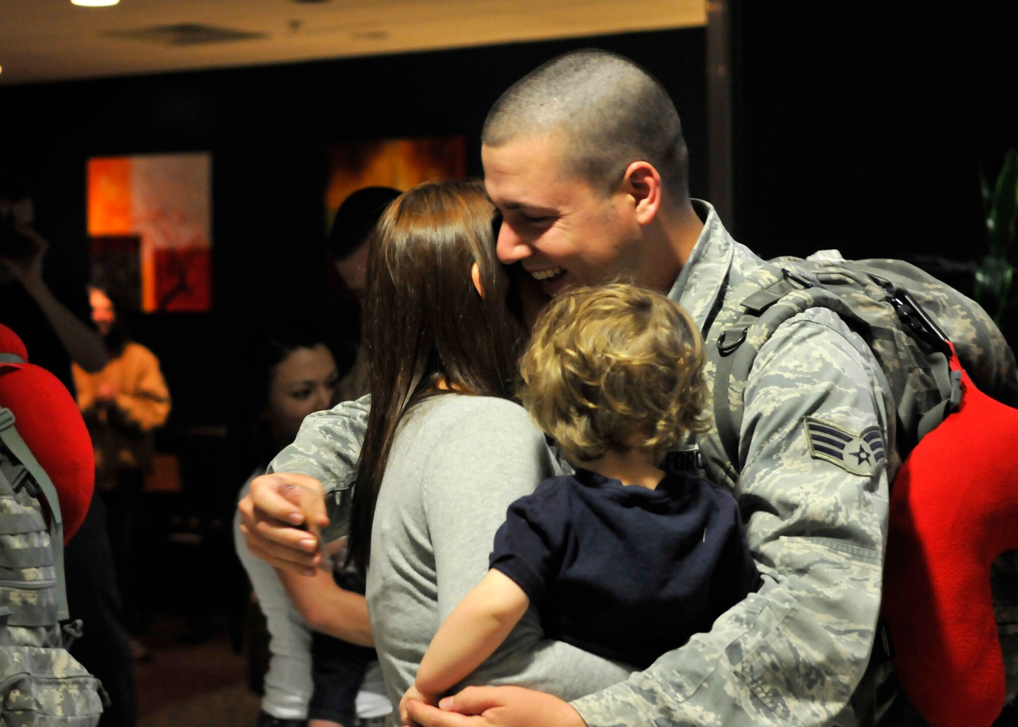 FORT WAYNE AIR NATIONAL GUARD BASE, Ind. – Senior Airman Aaron Strebig, 122nd Fighter Wing, Security Forces, embraces his family as the 122nd Fighter Wing welcomed home more than two-dozen members from the 122nd Security Forces Squadron, as they returned from a six-month deployment in support of Operation Enduring Freedom, January 23, 2015 at the Fort Wayne International Airport.  Twenty-six Blacksnakes mobilized for this deployment and were assigned to the 379th Expeditionary Security Forces Squadron at Al Udeid Air Base, Qatar. The group spent one month in San Antonio conducting combat preparation, then transitioned to Qatar for six months. 