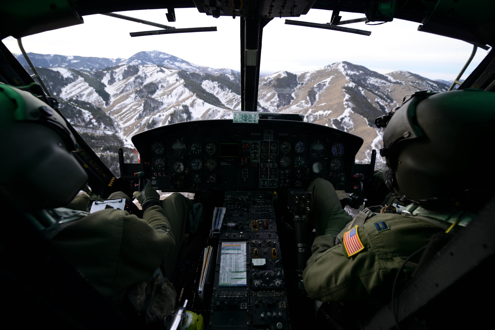 1st Lt. Greg Johnston, left, and Capt. RJ Bergman, both 40th Helicopter Squadron rescue pilots, fly their UH-1N Huey over a mountain range Jan. 27, 2015, near Malmstrom Air Force Base, Mont. The flight took the crew over a variety of terrain and altitudes, from flatlands to valleys and mountains. (U.S. Air Force photo/ Airman 1st Class Dillon Johnston)