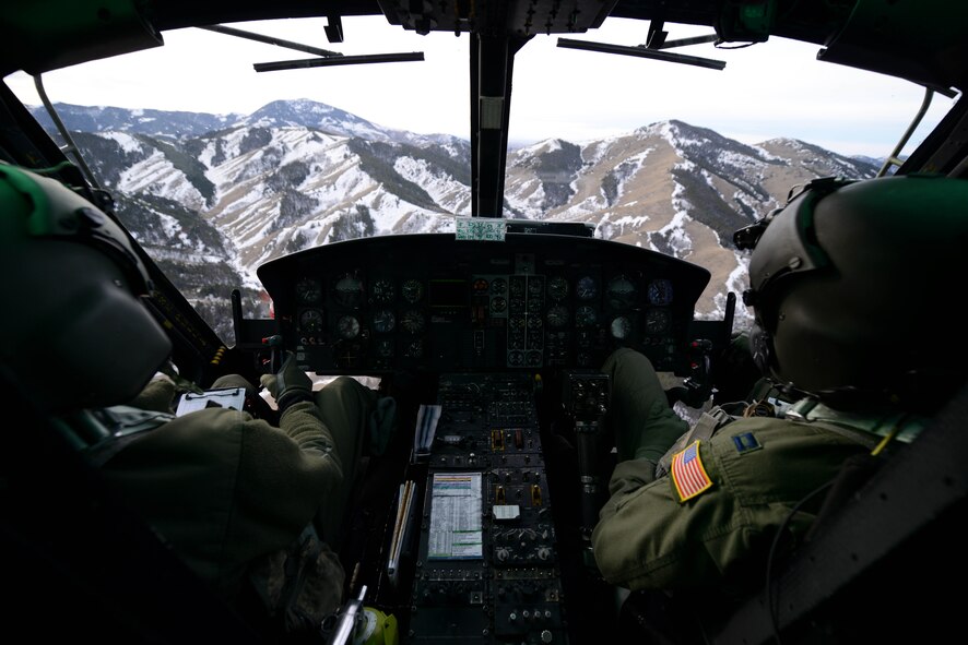 1st Lt. Greg Johnston, left, and Capt. RJ Bergman, both 40th Helicopter Squadron rescue pilots, fly their UH-1N Huey over a mountain range Jan. 27, 2015, near Malmstrom Air Force Base, Mont. The flight took the crew over a variety of terrain and altitudes, from flatlands to valleys and mountains. (U.S. Air Force photo/ Airman 1st Class Dillon Johnston)