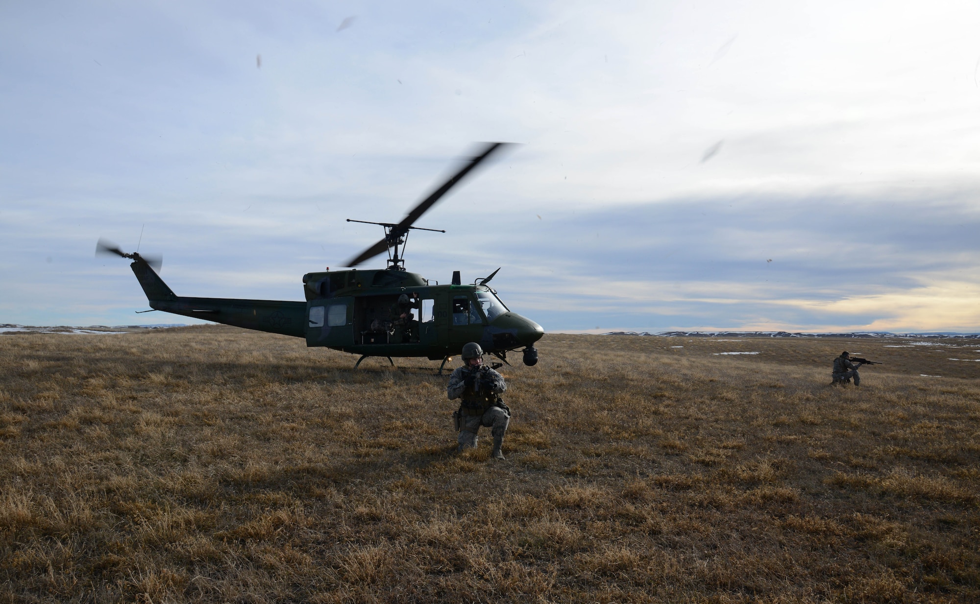 Senior Airman William Lamb, left, and Airman 1st Class Jordan Gilliand, both 341st Security Forces Group Tactical Response Force members, provide security as a UH-1N Huey lands for extraction. Lamb and Gilliand trained on infiltration and exfiltration from a helicopter during a routine launch facility security sweep. (U.S. Air Force photo/ Airman 1st Class Dillon Johnston)