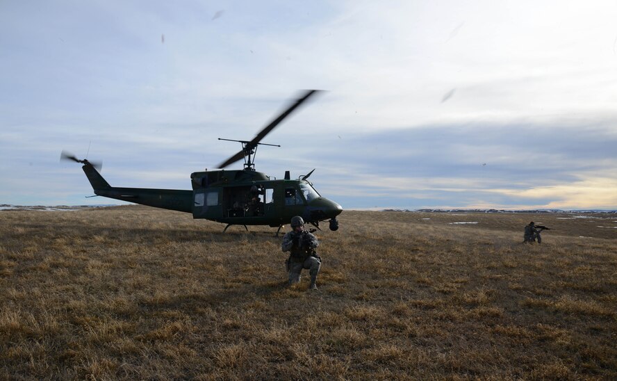 Senior Airman William Lamb, left, and Airman 1st Class Jordan Gilliand, both 341st Security Forces Group Tactical Response Force members, provide security as a UH-1N Huey lands for extraction. Lamb and Gilliand trained on infiltration and exfiltration from a helicopter during a routine launch facility security sweep. (U.S. Air Force photo/ Airman 1st Class Dillon Johnston)