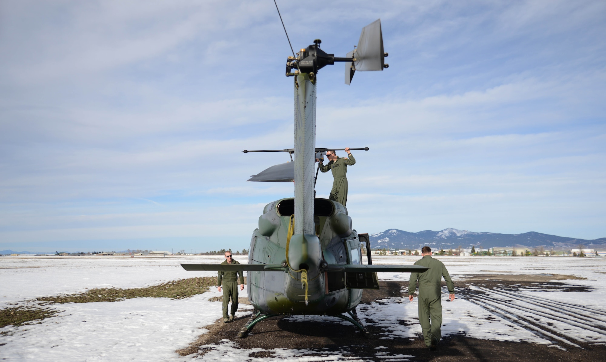 From left, 1st Lt. Greg Johnston, Capt. RJ Bergman, both 40th Helicopter Squadron rescue pilots, and Staff Sgt. Ryan Oliver, 40th HS special missions aviator, perform a post-flight inspection on their UH-1N Huey after landing it Jan. 27, 2015, at the Lewistown Municipal Airport in Lewistown, Mont. When off-base, a smaller scale inspection is performed, as there are no maintainers or tools available. (U.S. Air Force photo/ Airman 1st Class Dillon Johnston)