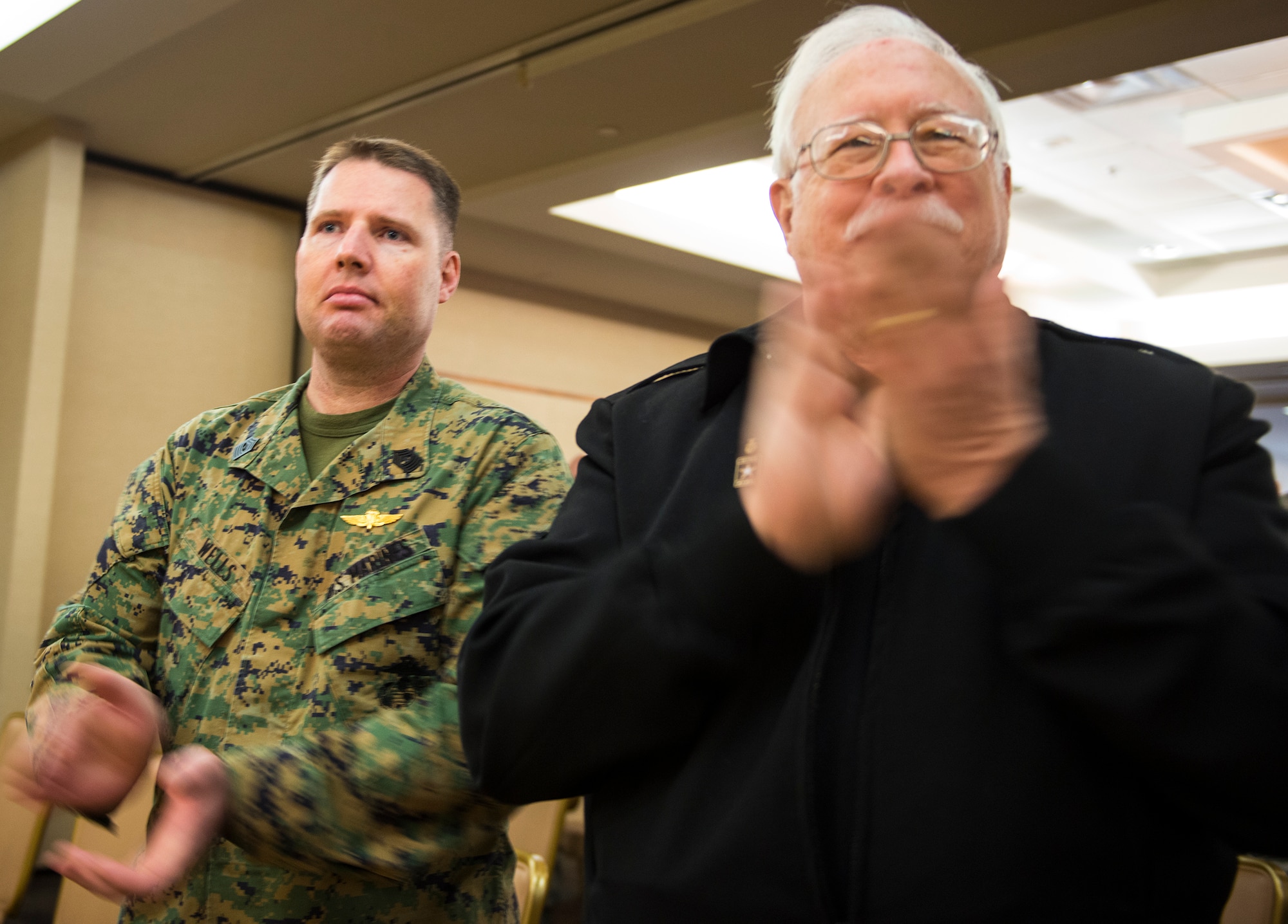 U.S. Marine Corps Master Gunnery Sgt. Richard Wells, senior enlisted advisor of Marine Special Operations School and Joe Parvin, the father of U.S. Air Force Maj. Jeremiah ‘Bull’ Parvin, 75th Fighter Squadron director of operations, cheer during the Distinguished Flying Cross with Valor Ceremony Jan. 29, 2015, at Moody Air Force Base, Ga. Wells was one of six Marines that ‘Bull’ saved on Oct. 28, 2008. (U.S. Air Force photo by Airman 1st Class Ceaira Tinsley/Released)