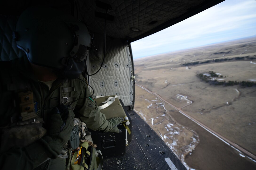 Staff Sgt. Ryan Oliver, 40th Helicopter Squadron special missions aviator, surveys the land as his UH-1N Huey sweeps the missile field for threats Jan. 27, 2015, near Malmstrom Air Force Base, Mont. Oliver provides critical situational awareness information to the pilots, allowing them to safely navigate more dangerous terrain. (U.S. Air Force photo/ Airman 1st Class Dillon Johnston)
