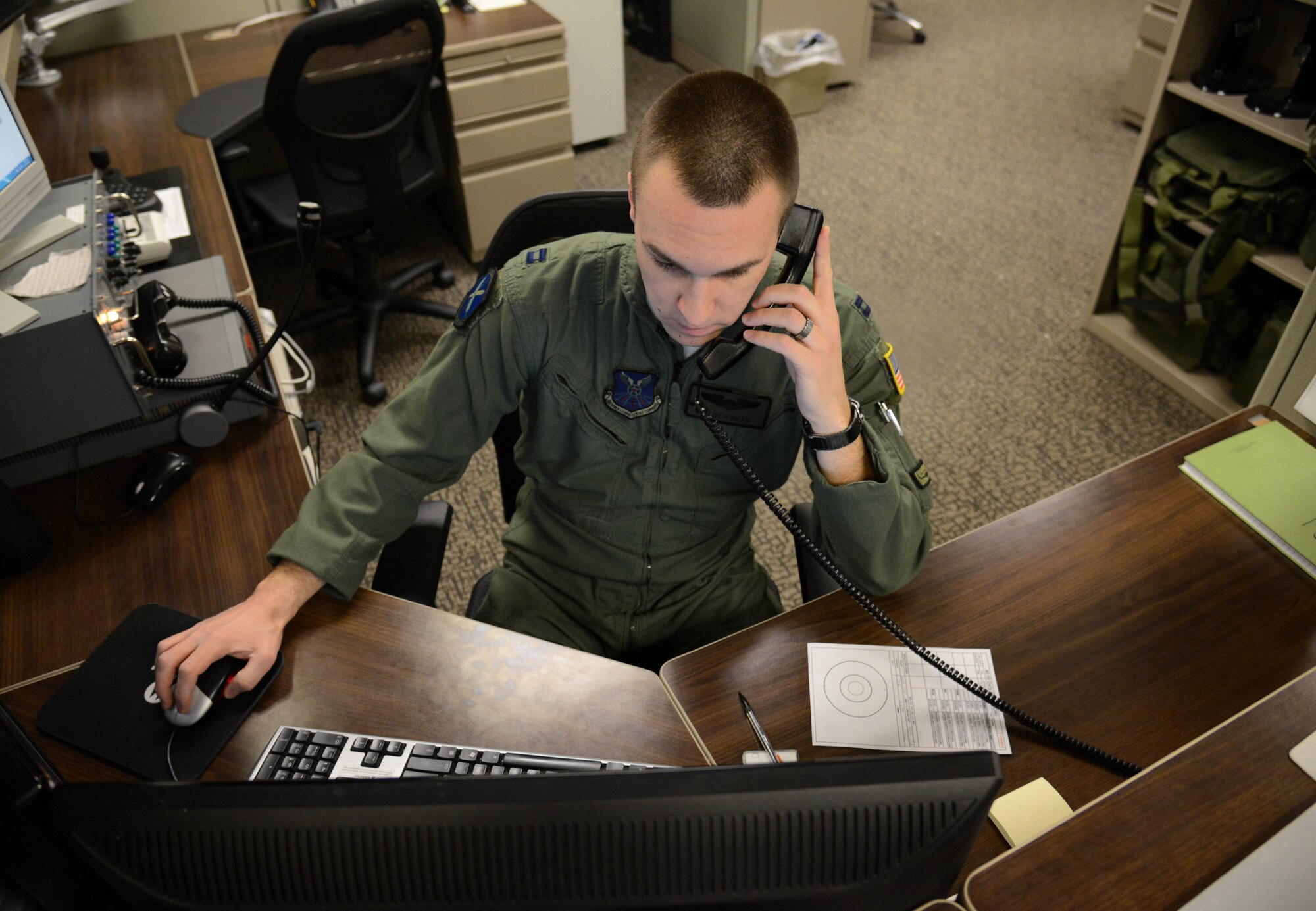 Capt. RJ Bergman, 40th Helicopter Squadron rescue pilot, coordinates with other agencies in the squadron prior to a flight Jan. 27, 2015, at Malmstrom Air Force Base, Mont. Working together with the weather flight, maintenance and scheduling personnel ensures the flight takes off on time. (U.S. Air Force photo/ Airman 1st Class Dillon Johnston)