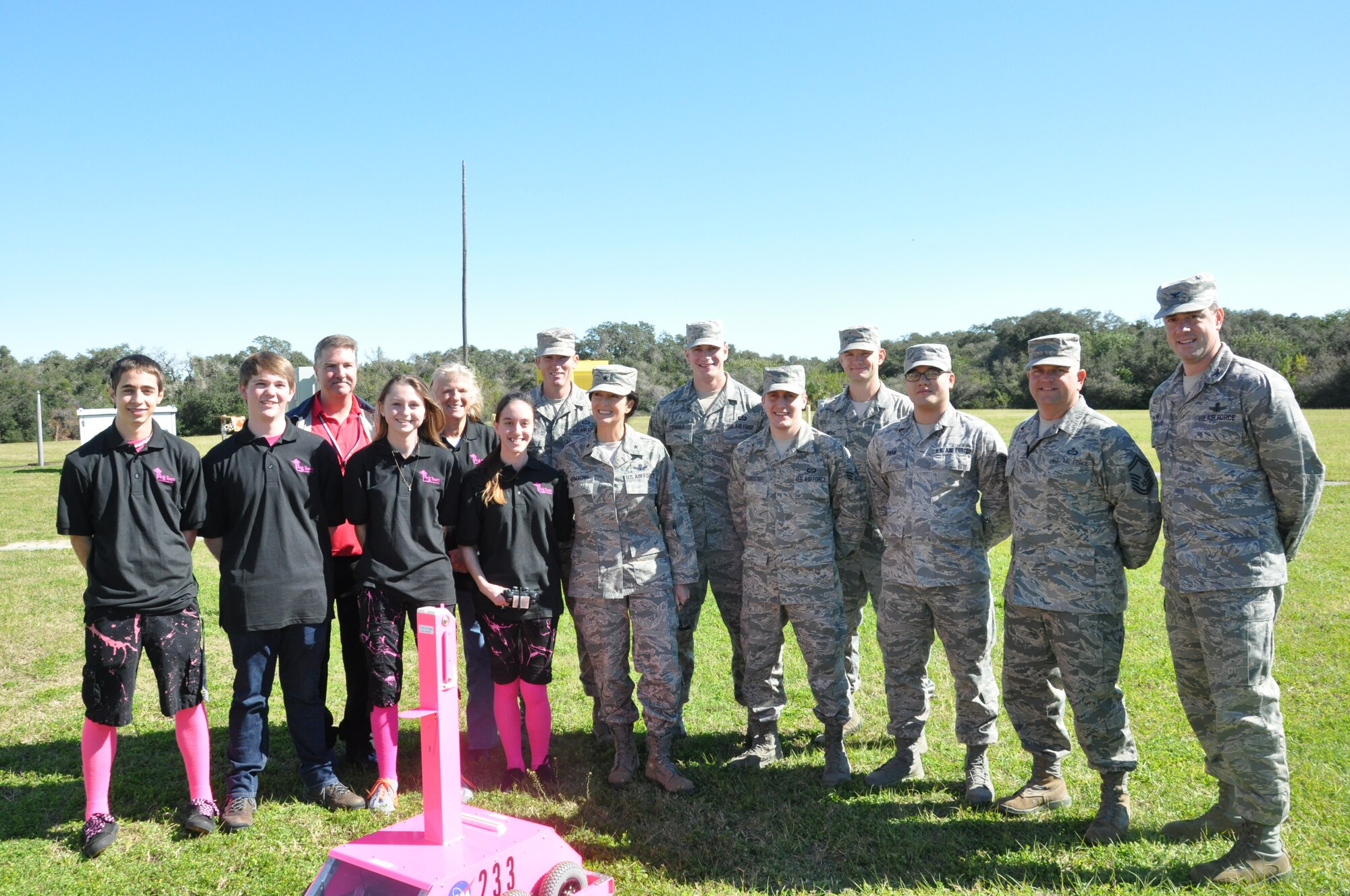 Brig. Gen. Nina Armagno, commander, 45th Space Wing, front row center, happily poses with members of the PINK Team, a high school robotics team that unveiled the Eastern Range Weatherbot Tuesday morning at Cape Canaveral Air Force Station. Team members are (left to right) Nick McAleenan, Wyatt Vining, Stephanie Dawson and Jordan Geon. In back row, (far left), is NASA engineer and team mentor Andy Bradley, and (second from left) is Marian Passmore, the teacher-sponsor for the project. Also pictured are Airmen assigned with the 45th Space Wing, to include Col.Thomas Falzarano, commander, 45th Operations Group, far right. (Photo by Chris Calkins)
