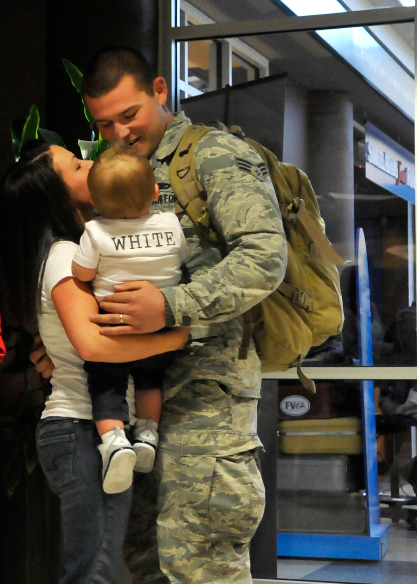 FORT WAYNE AIR NATIONAL GUARD BASE, Ind. – Senior Airman Mathew White, 122nd Fighter Wing, Security Forces, embraces his wife and son as the 122nd Fighter Wing welcomed home more than two-dozen members from the 122nd Security Forces Squadron, as they returned from a six-month deployment in support of Operation Enduring Freedom, January 23, 2015 at the Fort Wayne International Airport.  Twenty-six Blacksnakes mobilized for this deployment and were assigned to the 379th Expeditionary Security Forces Squadron at Al Udeid Air Base, Qatar. The group spent one month in San Antonio conducting combat preparation, then transitioned to Qatar for six months. 