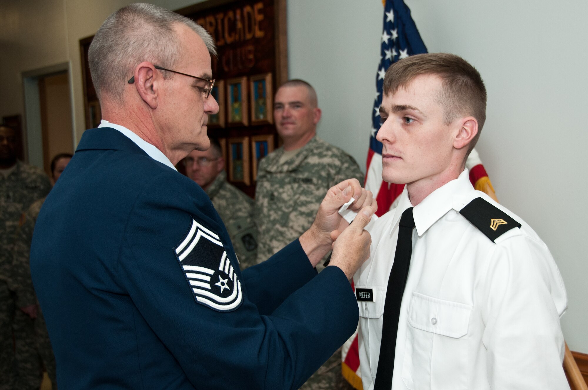 Air Force Reserve Senior Master Sgt. Volker Kiefer, 914th Aeromedical Evacuation Squadron, pins the Non-Commissioned Officer rank of Sergeant to his son, U.S. Army Sergeant Andrew Kiefer, HHC Special Troop Battalion, Fort Drum N.Y. December 3, 2014.  (U.S. Army photo by Staff Sgt. Michael Selvage)