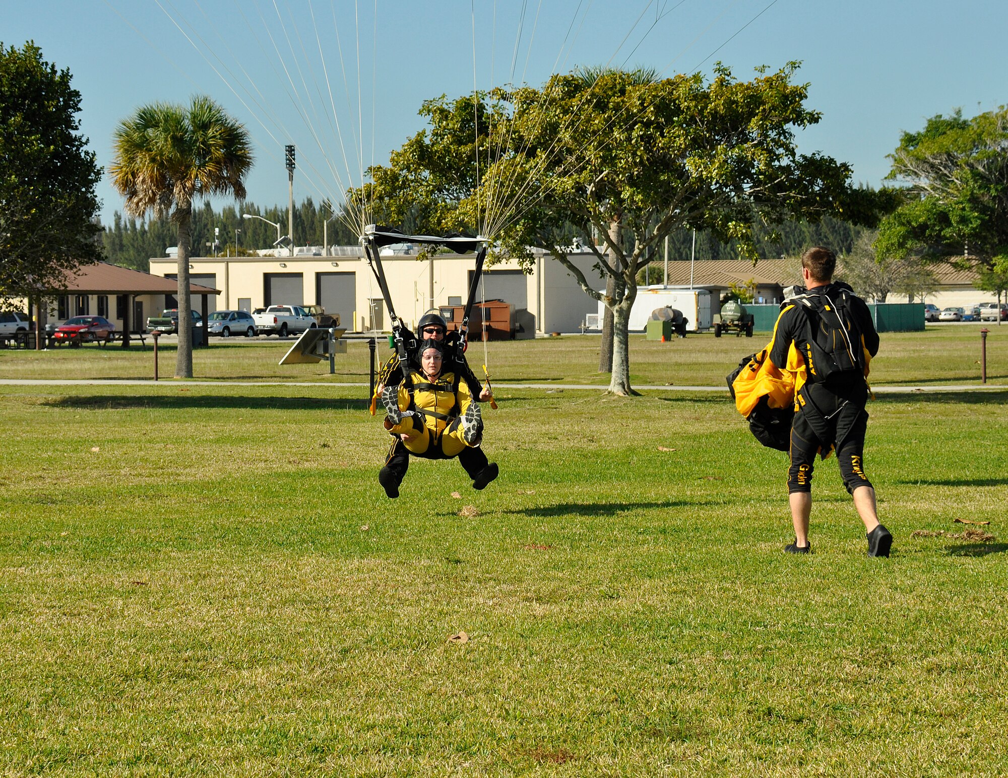 Sgt. 1st Class Jon Ewald, tandem instructor with the U.S. Army Parachute Team: The Golden Knights, and Maj. Brooke Cortez, 482nd Fighter Wing Public Affairs chief, prepare to land after a tandem jump at Homestead Air Reserve Base, Fla., on Jan. 29. The Golden Knights are conducting their sixth straight year of winter training at Homestead ARB. (U.S. Air Force photo/Tim Norton)