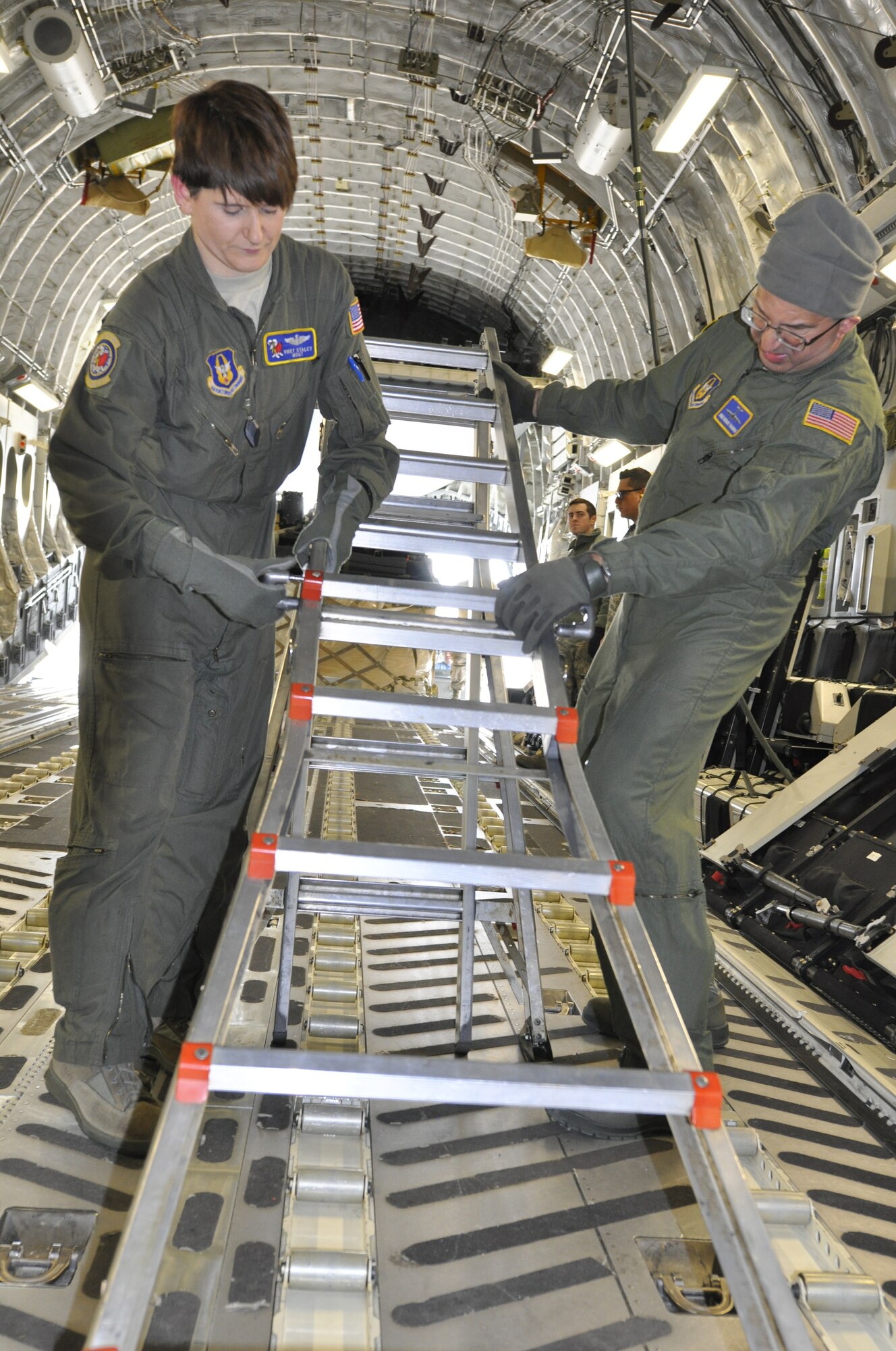Loadmaster, Master Sgt. Victoria Staley and crew chief Staff Sgt. Michael Thalman of the 514th Air Mobility Wing, put away equipment after reconfiguring of the belly of the C-17 to accommodate seven pallets of humanitarian cargo. Reserve crews loaded the cargo Jan. 17 at Charleston Air Force Base, S.C., and delivered it Haiti Jan. 18. (Air Force photo/Master Sgt. Donna T. Jeffries)