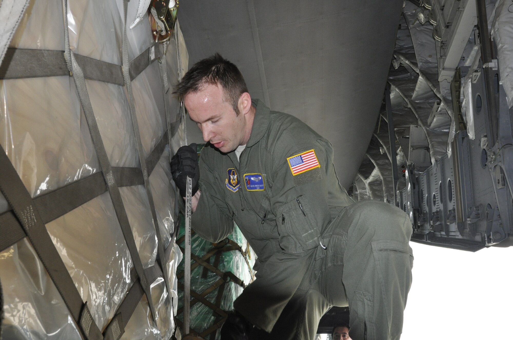 Staff Sgt. Wayne Groeblinghoff, a loadmaster with the 732nd Airlift Squadron, positions a one of seven pallets in place on board a C-17 Globemaster Jan 17. The Reserve aircrew delivered the Denton Humanitarian cargo to Haiti the following day. (Air Force photo/Master Sgt. Donna T. Jeffries)