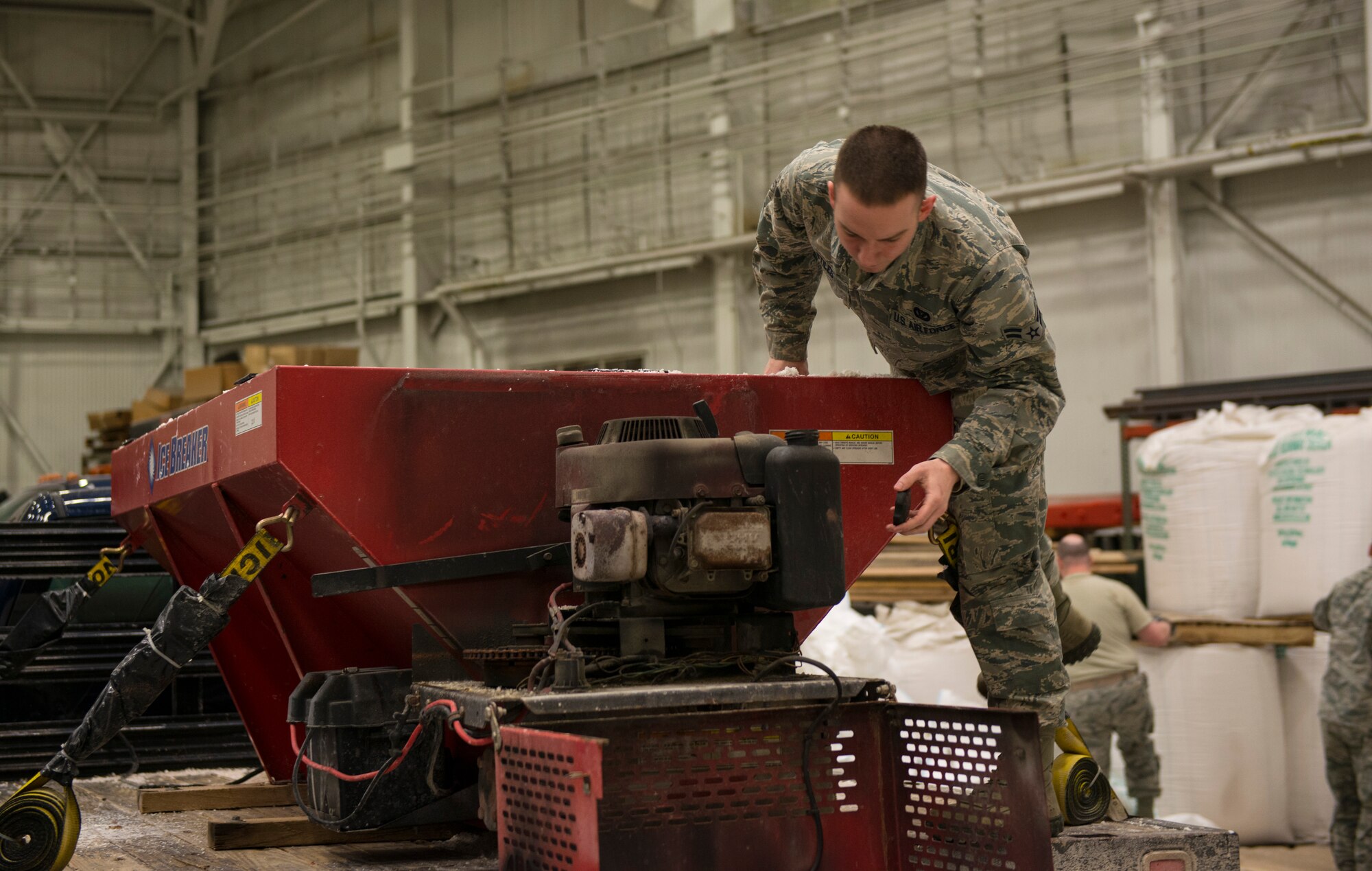 Airman 1st Class Robert Stiles, 87th Civil Engineer Squadron technician, checks the fuel levels on the engine of a salt dispenser before going out and salting the roads of Joint Base McGuire-Dix-Lakehurst, N.J., Jan. 26, 2015. The 87th CES members worked 12 hour shifts to prepare for and then clean up after Winter Storm Juno. (U.S. Air Force photo by Airman 1st Class Joshua D. King/Released)