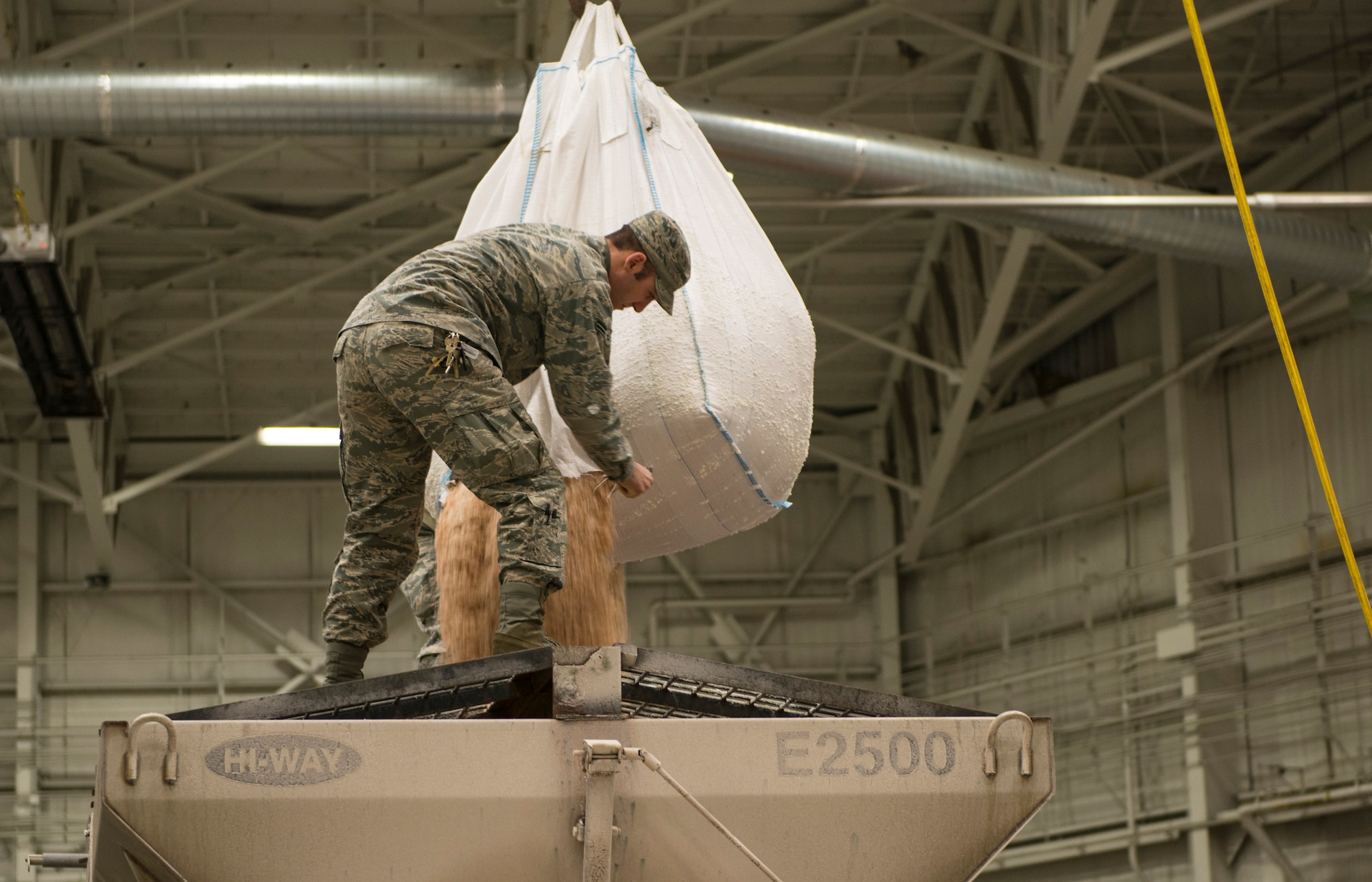 Airman 1st Class Joseph Betal, 87th Civil Engineer Squadron technician, cuts open a bag of salt in order to fill a salt truck on Joint Base McGuire-Dix-Lakehurst, N.J., Jan. 26, 2015. The 87th CES members worked 12 hour shifts to prepare for and then clean up after Winter Storm Juno. (U.S. Air Force photo by Airman 1st Class Joshua D. King/Released)
