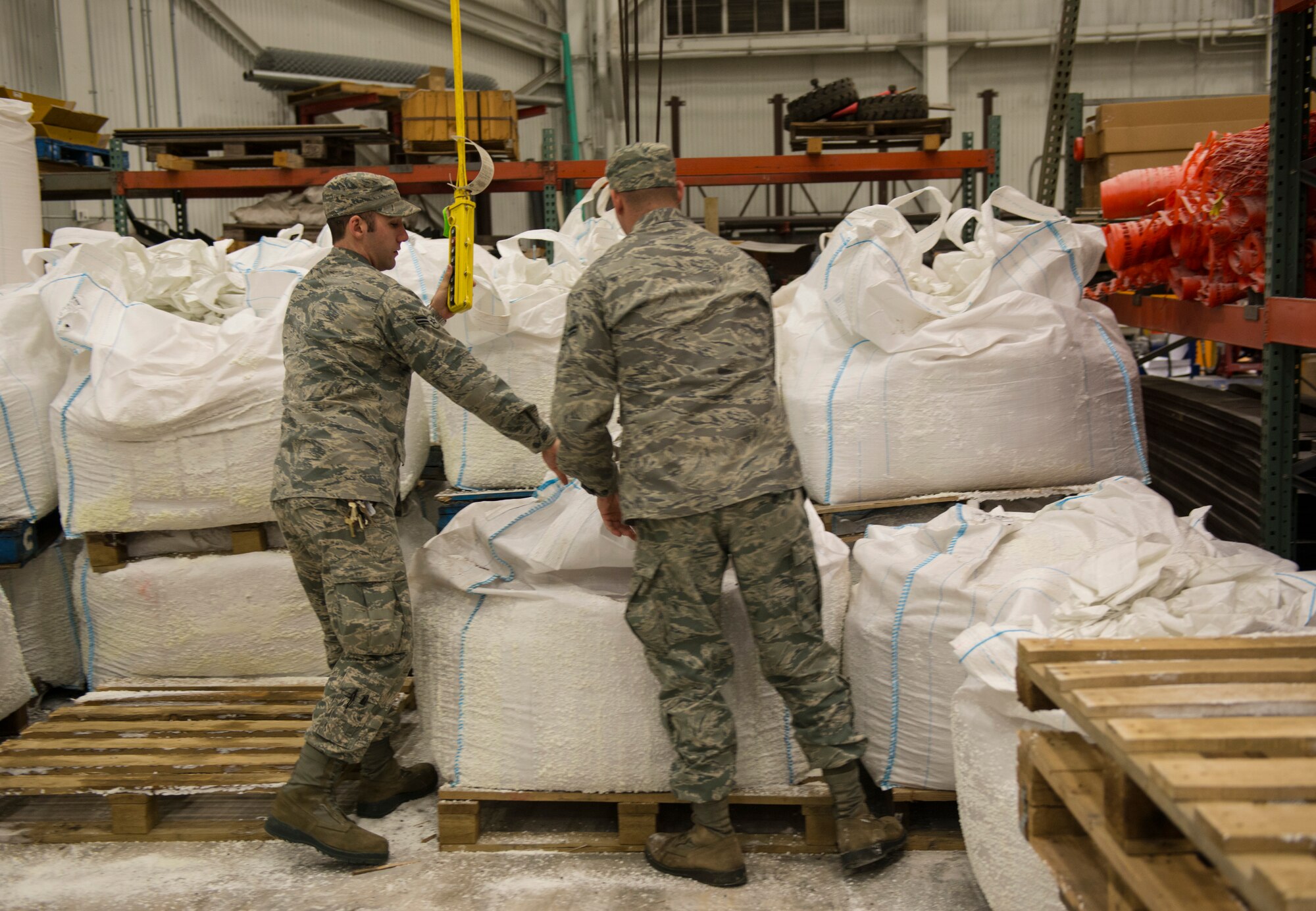 Airmen 1st Class Joseph Betal and Nickalas Boomershine, 87th Civil Engineer Squadron technicians, prepare to move to bag of salt to a salt truck on Joint Base McGuire-Dix-Lakehurst, N.J., Jan. 26, 2015. The 87th CES members worked 12 hour shifts to prepare for and then clean up after Winter Storm Juno. (U.S. Air Force photo by Airman 1st Class Joshua D. King/Released)