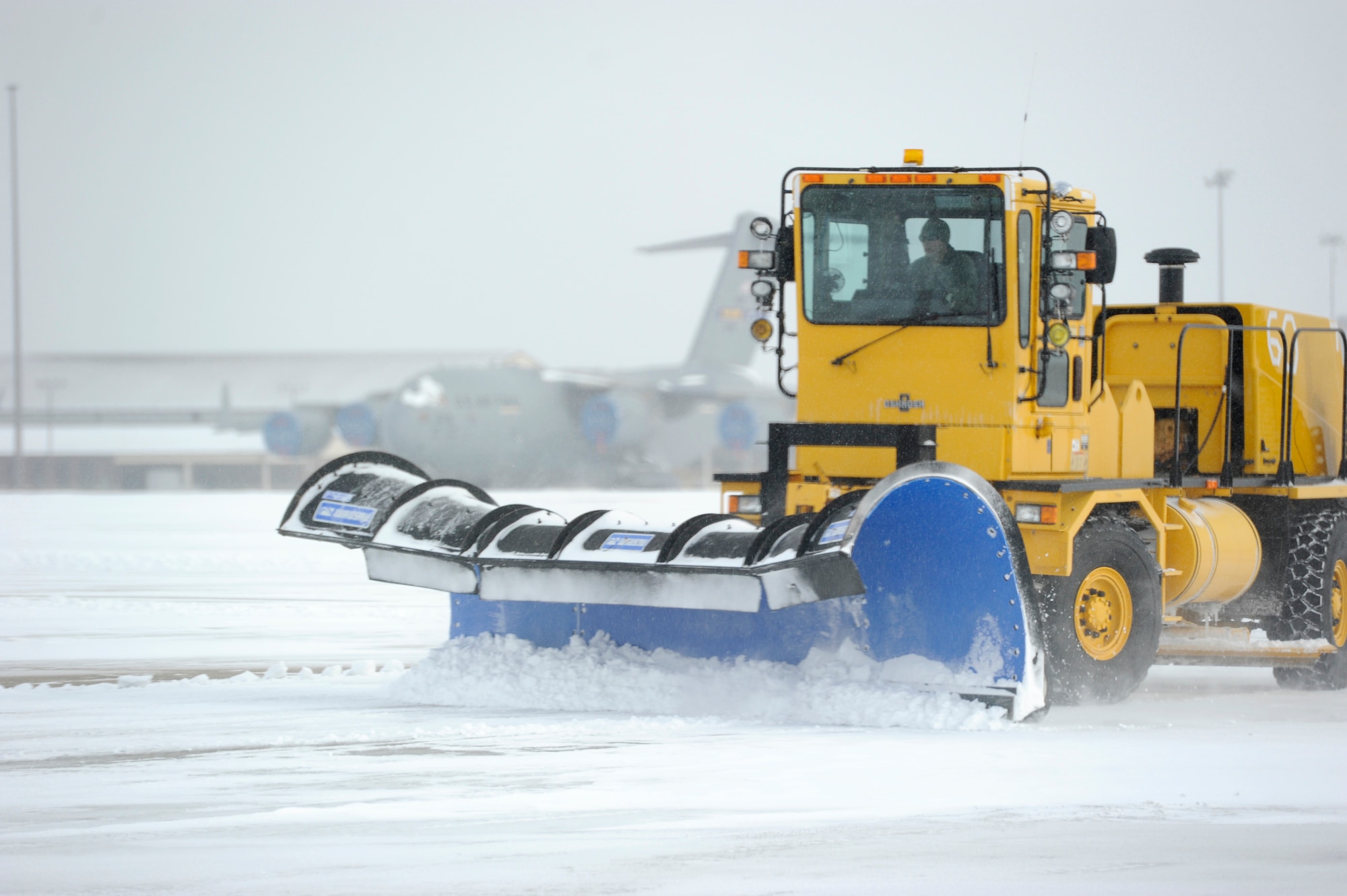 An 87th Civil Engineer Squadron member operates a snow plow to clear a taxiway Jan. 27, 2015, at Joint Base McGuire-Dix-Lakehurst, N.J. The 87th CES members worked around the clock to clear the aftermath of Winter Storm Juno, returning the base to normal operations. (U.S. Air Force photo by Airman 1st Class Sean M. Crowe/Released)
