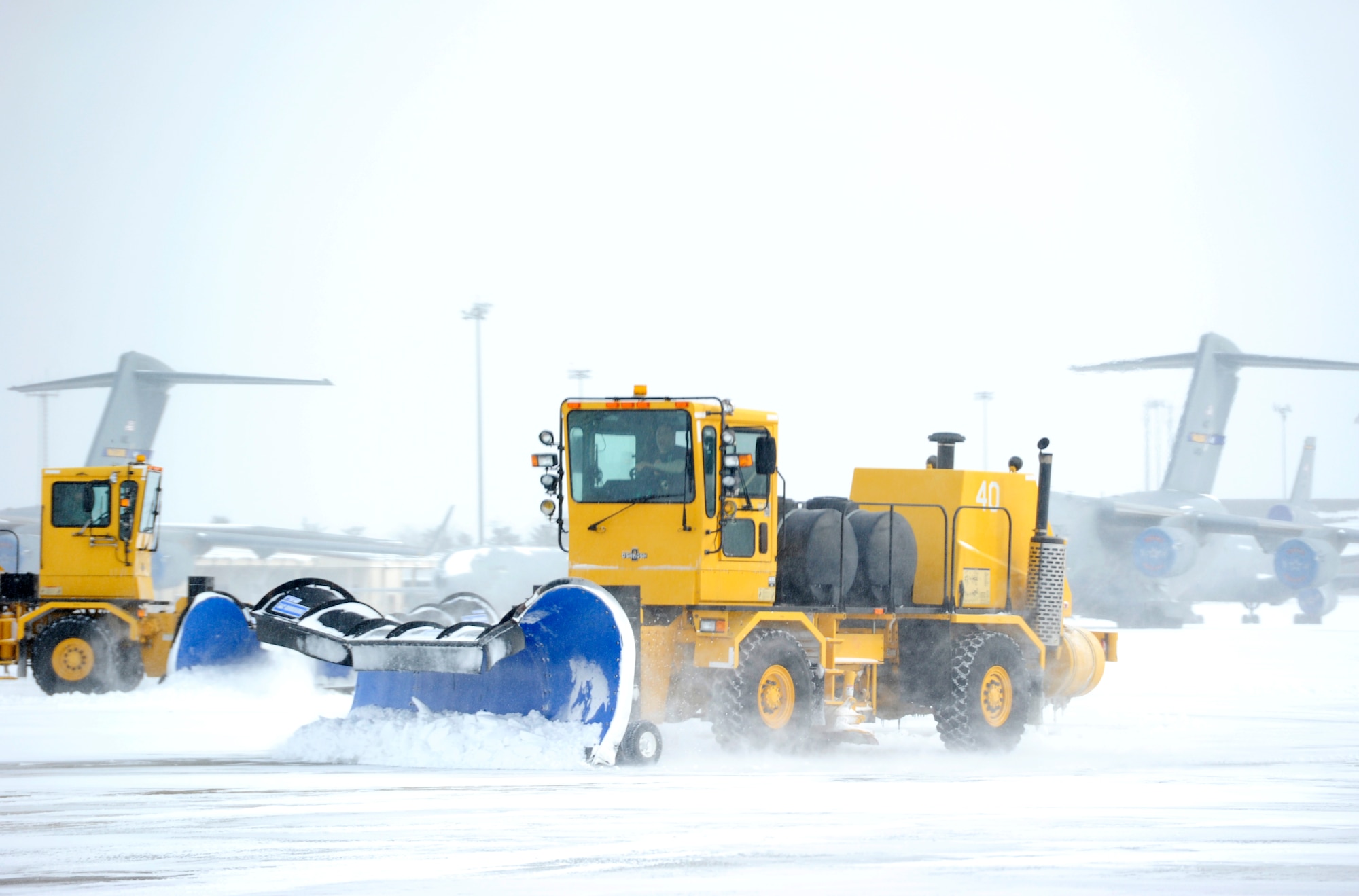 An 87th Civil Engineer Squadron member operates a snow plow to clear a taxiway Jan. 27, 2015, at Joint Base McGuire-Dix-Lakehurst, N.J. The 87th CES members worked around the clock to clear the aftermath of Winter Storm Juno, returning the base to normal operations. (U.S. Air Force photo by Airman 1st Class Sean M. Crowe/Released)