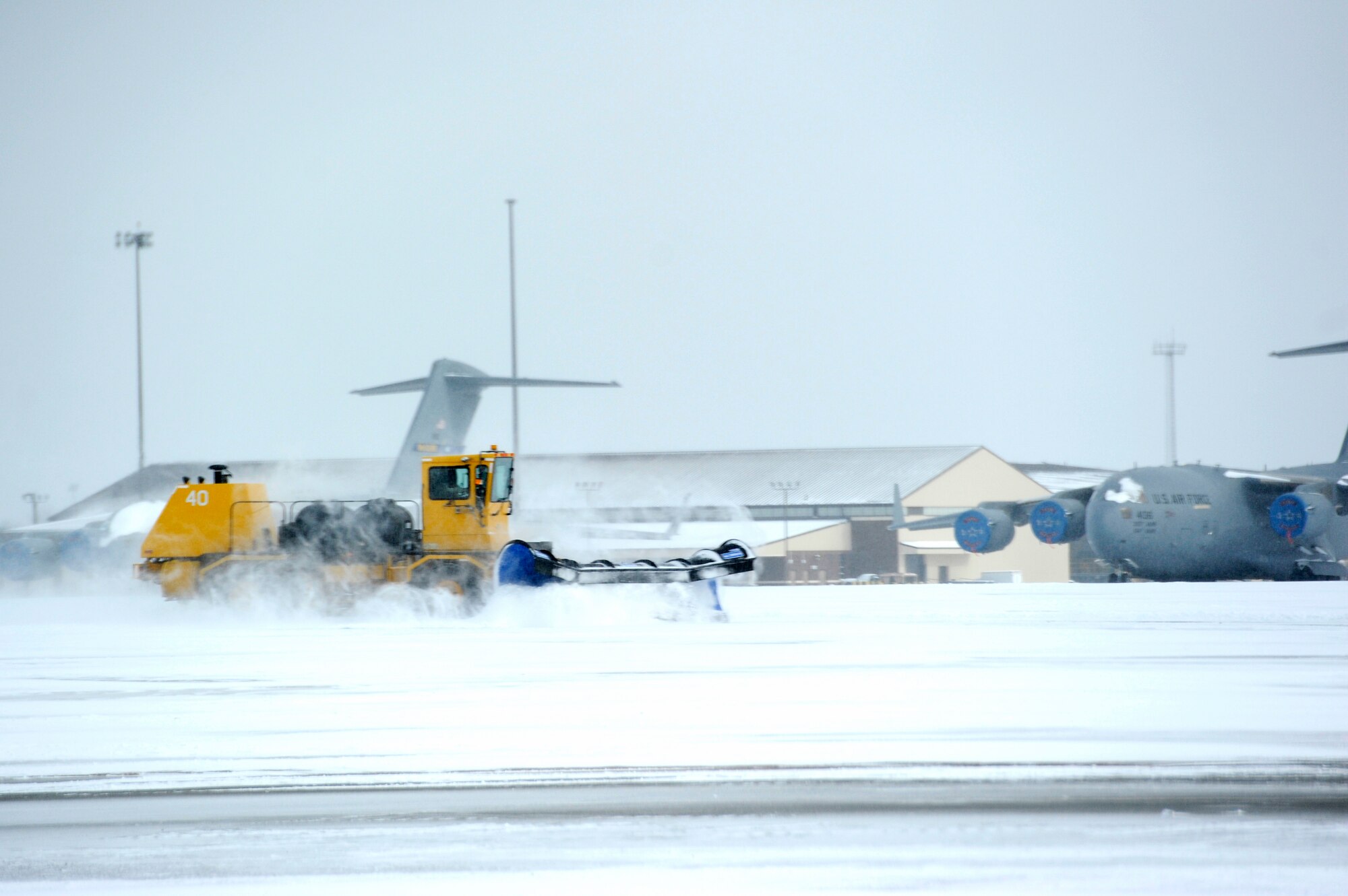 An 87th Civil Engineer Squadron member operates a snow plow to clear a taxiway Jan. 27, 2015, at Joint Base McGuire-Dix-Lakehurst, N.J. The 87th CES members worked around the clock to clear the aftermath of Winter Storm Juno, returning the base to normal operations. (U.S. Air Force photo by Airman 1st Class Sean M. Crowe/Released)
