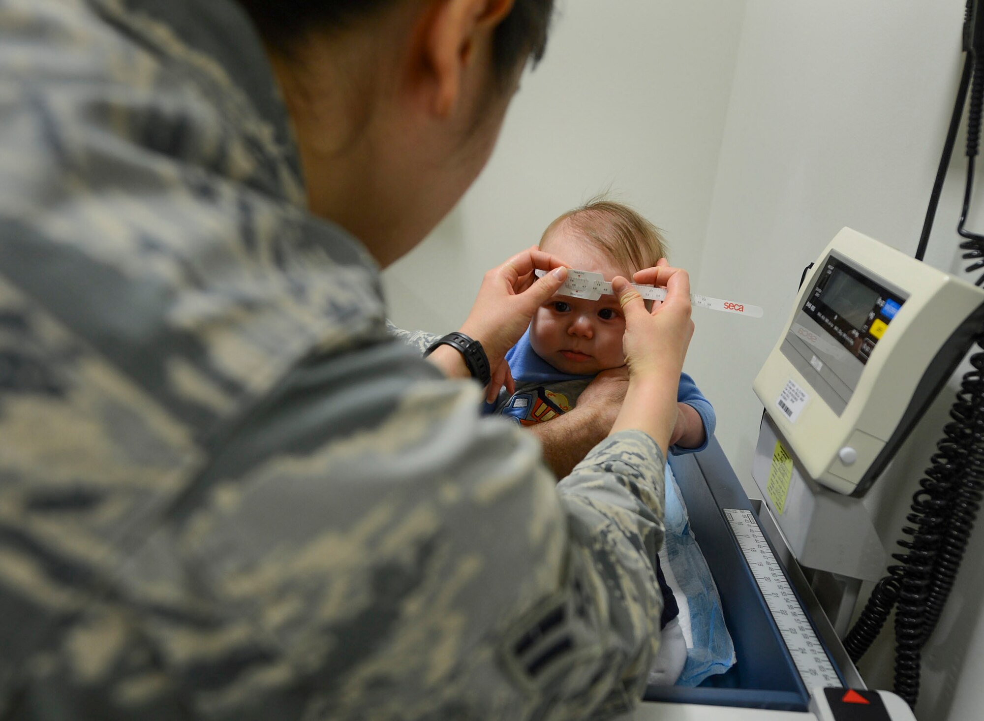 Airman 1st Class Jasmine Perkins, 48th Medical Operations Squadron medical technician, takes a cranial measurement of James Bondeson, 4-month-old military dependent, at Royal Air Force Lakenheath, England, Jan. 22, 2015. Well-child visits ensure proper growth of children during their first year of life. (U.S. Air Force photo by Airmen 1st Class Dawn M. Weber/Released)