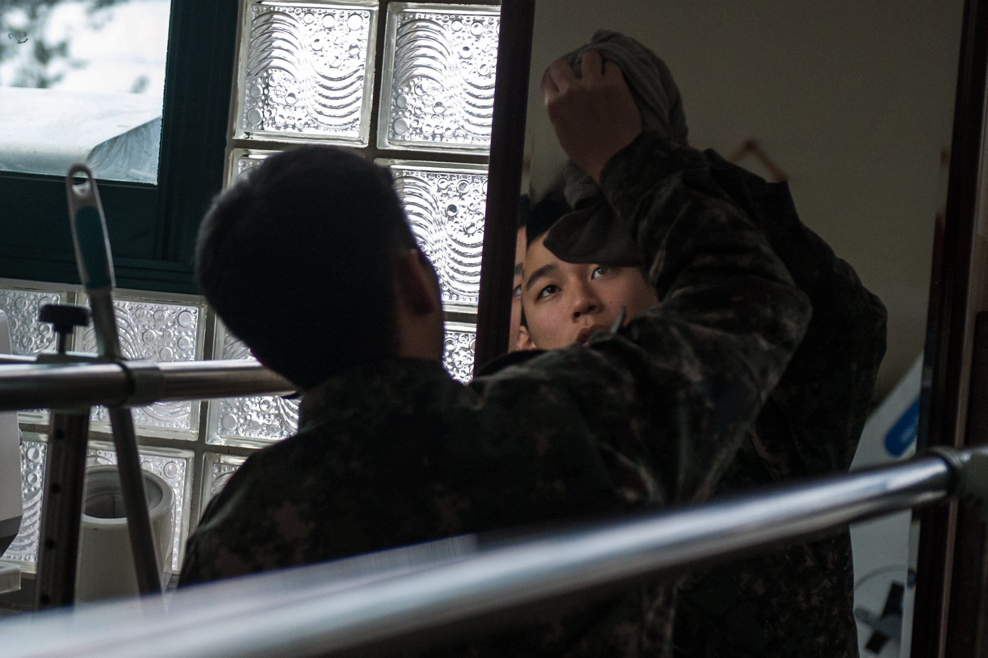 A member of the Republic of Korea Air Force cleans a mirror while volunteering at the Gunsan City Rehabilitation Center in Gunsan City, Republic of Korea, Jan. 22, 2015. ROKAF and U.S. Air Force members volunteered for the day at the rehabilitation center as part of a monthly community service project. (U.S. Air Force photo by Senior Airman Taylor Curry/Released) 
