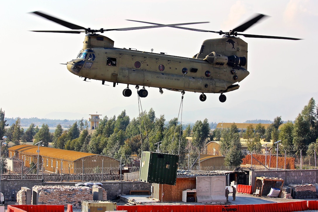 A CH-47 Chinook helicopter lifts off with a shipping container during slingload operations on Tactical Base Gamberi, Laghman province, Afghanistan, Jan. 23, 2015.
