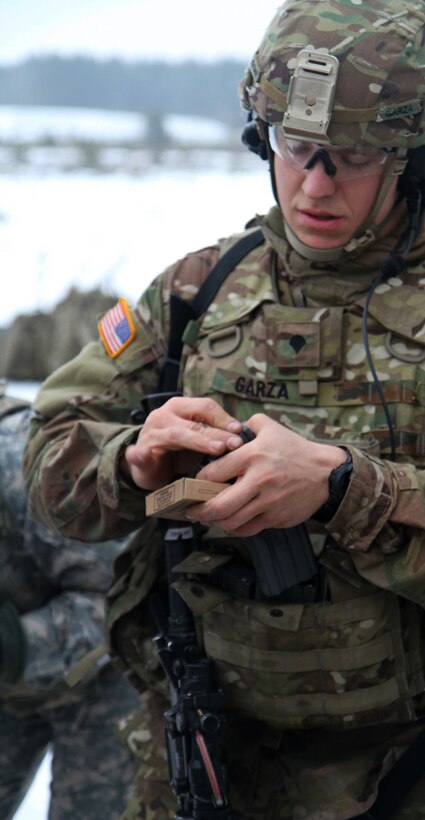 A U.S. Army soldier loads his weapon with ammo prior to a squad training exercise in Adazi, Latvia, Jan. 28, 2015. 