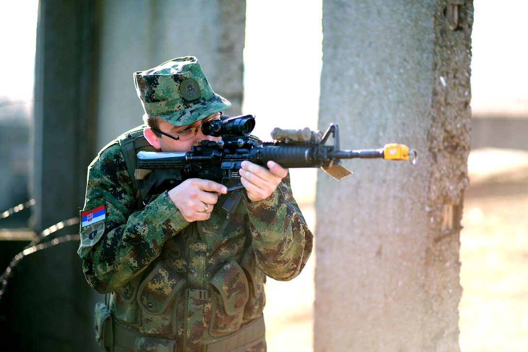 Lance Cpl. Dejan Stefanovic provides security as Marines breach a doorway at the military operations on urbanized terrain course. Serbians conducted MOUT training with Marines at Novo Selo training area in Bulgaria, Jan. 17, 2015, as part of Exercise Platinum Lion.