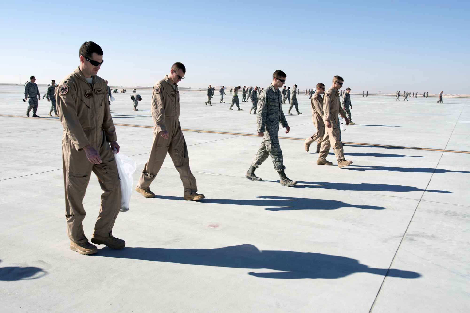 More than 100 Airmen gathered to conduct their first Foreign Object Damage walk on a new tactical aircraft ramp at Al Udeid Air Base, Qatar, on Jan 29, 2015.The new ramp will alleviate the congestion of aircraft being launched and recovered in support of various operations in the U.S. Central Command area of responsibility. (U.S. Air Force photo by Master Sgt. Kerry Jackson) 