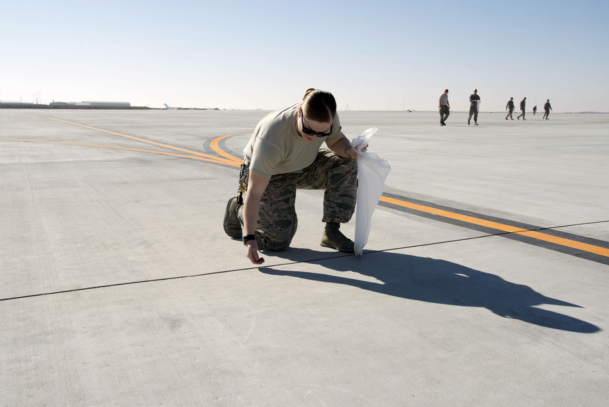 U.S. Air Force Staff Sgt. Janice Jacques, 379th Expeditionary Security Forces Squadron, and more than 100 Airmen gathered to conduct their first Foreign Object Damage walk on a new tactical aircraft ramp at Al Udeid Air Base, Qatar, on Jan 29, 2015. The new ramp will alleviate the congestion of aircraft being launched and recovered in support of various operations in the U.S. Central Command area of responsibility. (U.S. Air Force photo by Master Sgt. Kerry Jackson) 