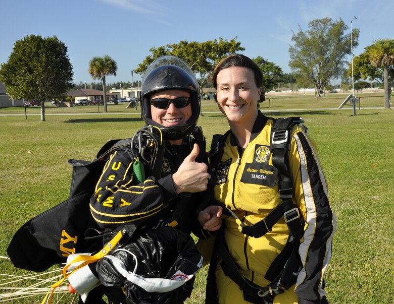 Sgt. 1st Class Jon Ewald, tandem instructor with the U.S. Army Parachute Team: The Golden Knights, gives a thumbs-up with Maj. Brooke Cortez, 482nd Fighter Wing Public Affairs chief, after a successful tandem jump at Homestead Air Reserve Base, Fla., on Jan. 29. The Golden Knights are conducting their sixth straight year of winter training at Homestead ARB. (U.S. Air Force photo/Tim Norton)