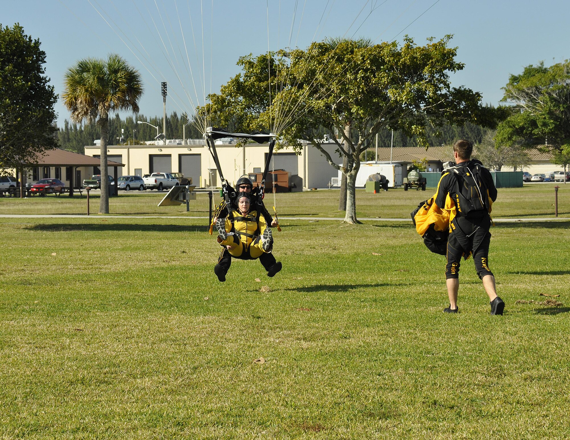 Sgt. 1st Class Jon Ewald, tandem instructor with the U.S. Army Parachute Team: The Golden Knights, and Maj. Brooke Cortez, 482nd Fighter Wing Public Affairs chief, prepare to land after a tandem jump at Homestead Air Reserve Base, Fla., on Jan. 29. The Golden Knights are conducting their sixth straight year of winter training at Homestead ARB. (U.S. Air Force photo/Tim Norton)