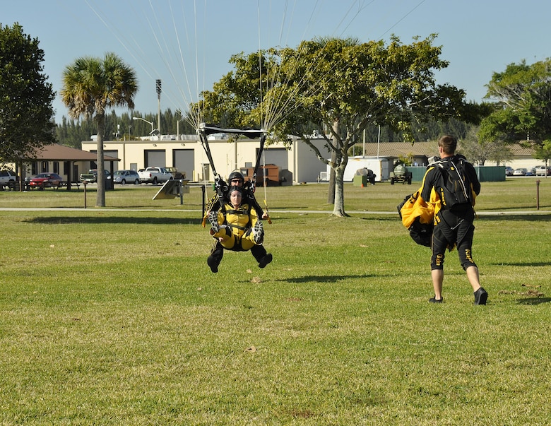 Sgt. 1st Class Jon Ewald, tandem instructor with the U.S. Army Parachute Team: The Golden Knights, and Maj. Brooke Cortez, 482nd Fighter Wing Public Affairs chief, prepare to land after a tandem jump at Homestead Air Reserve Base, Fla., on Jan. 29. The Golden Knights are conducting their sixth straight year of winter training at Homestead ARB. (U.S. Air Force photo/Tim Norton)