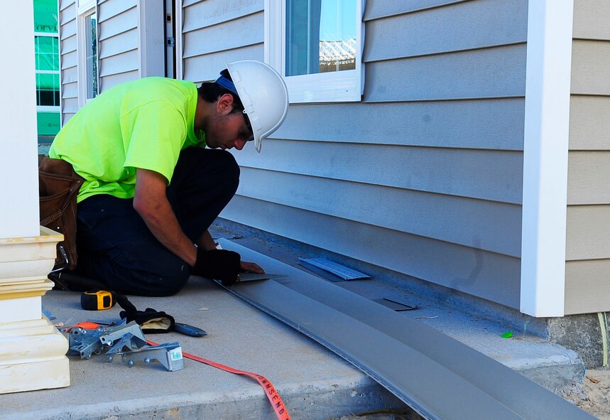 A construction worker installs paneling to a home in the Osprey Landing neighborhood at Hurlburt Field, Fla., Jan. 28, 2015. Once the homes are completed, Corvias property management will assign homes to Hurlburt members and families. (U. S. Air Force photo/Airman 1st Class Andrea Posey)