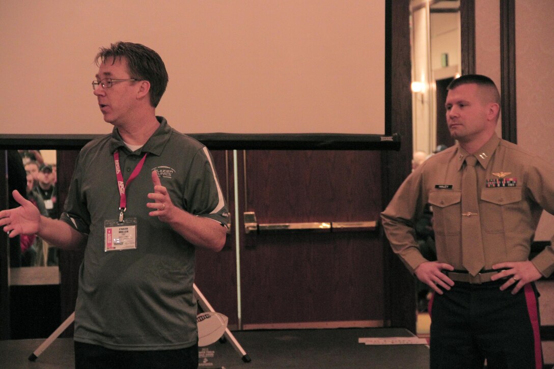Capt. Joseph Haley, operations officer, RS Indianapolis, is introduced before the Semper Fi Coaches Award ceremony at the 2015 Glazier Coaches Clinics in Indianapolis Jan. 24, 2015