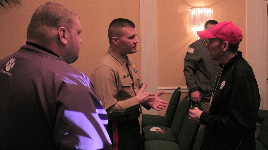 Capt. Joseph Haley, operations officer, RS Indianapolis, talks one-on-one with high school football coaches about the Marine Corps at 2015 Glazier Coaches Clinics in Indianapolis Jan. 24. 