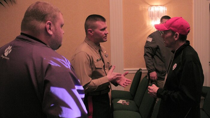 Capt. Joseph Haley, operations officer, RS Indianapolis, talks one-on-one with high school football coaches about the Marine Corps at 2015 Glazier Coaches Clinics in Indianapolis Jan. 24. 