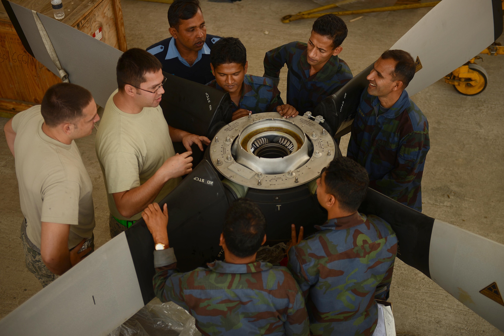 Tech. Sgt. Sam Bishop, center left, and Staff Sgt. Jeffrey Stephens discuss propeller maintenance with Bangladesh air force maintainers, from the 101st Special Flying Unit, during exercise Cope South 15 Jan. 27, 2015, at BAF Base Bangabandhu, Bangladesh. Bishop and Stephens are aerospace propulsion specialists assigned to the 374th Maintenance Group at Yokota Air Base, Japan. (U.S. Air Force photo/1st Lt. Jake Bailey) 