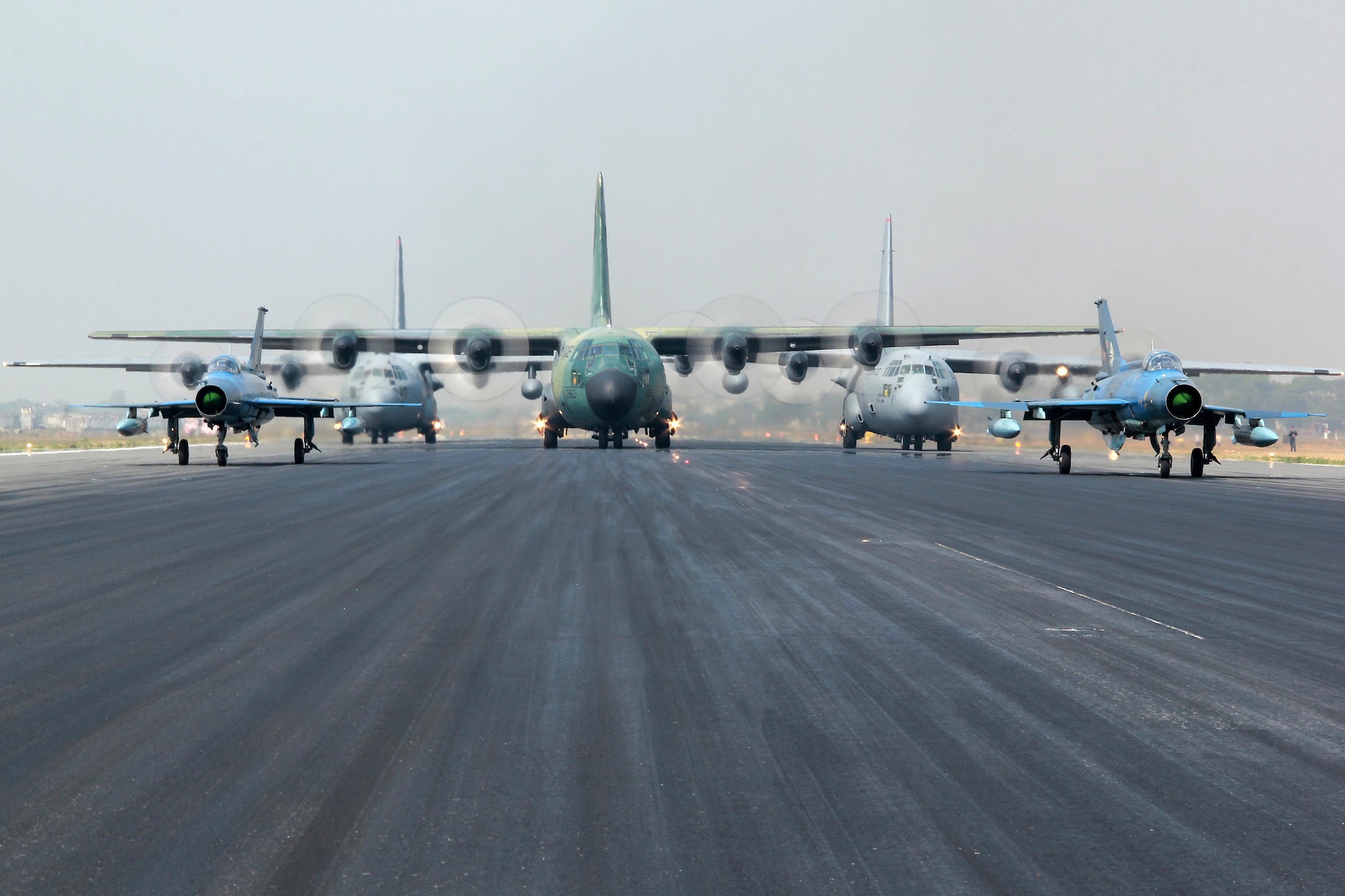 Two Bangladesh F-7BG Defenders, a BAF C-130B Hercules, and two U.S. Air Force C-130H Hercules aircraft prepare to take off Jan. 28, 2015, from BAF Base Bangabandhu, Bangladesh, during Cope South 15. The C-130H is assigned to the 374th Airlift Wing at Yokota Air base, Japan; the BAF F-7BGs are assigned to 5th Squadron and the BAF C-130B is assigned to 101st Special Flying Unit at BAF Base Bangabandhu, Bangladesh. (Courtesy photo/Bangladesh air force)