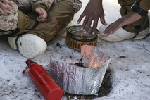 U.S. Marines with Combat Logistics Battalion 26, Headquarters Regiment, 2nd Marine Logistics Group, warm their hands over a small fire during a training exercise aboard U.S. Marine Corps Mountain Warfare Training Center at Bridgeport, California, Jan. 24, 2015. The Marines used their portable stove to generate a flame used to boil water and heat Cold Weather Meals Ready-To-Eat. (U.S. Marine Corps photo by Lance Cpl. Kaitlyn Klein/Released)